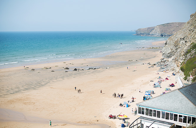 Looking down across the sweeping sands and steep cliffs at Watergate Bay