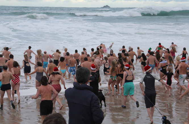 A crowd of people going for a Christmas Day swim in Cornwall
