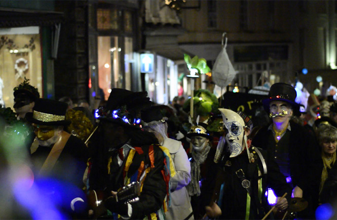 People parading through Penzance in costumes as a part of the Montol Festival