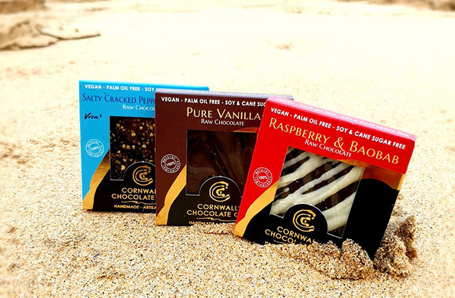 Three of the delicious vegan chocolate bars by Cornwall's Chocolate Cove sitting in the sand