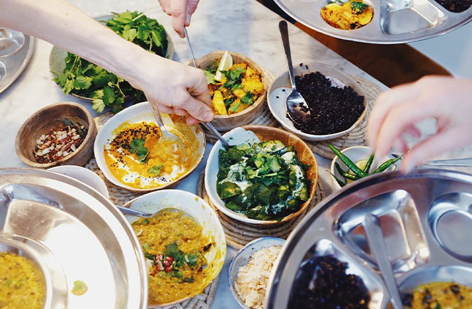 People helping themselves to a vegan Thali at Wilder Kitchen