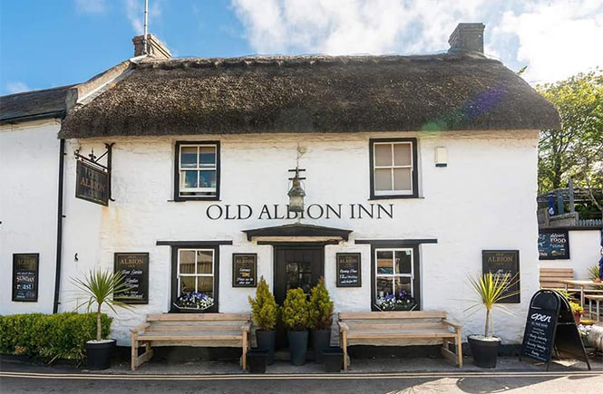The white-washed and thatched exterior of the Old Albion Inn