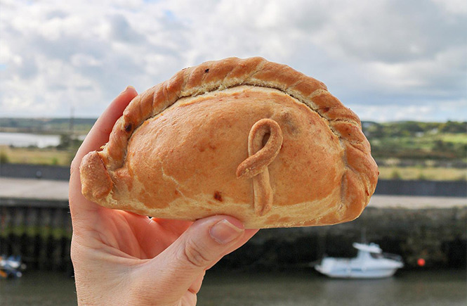 Someone holding up a Cornish pasty by Philps