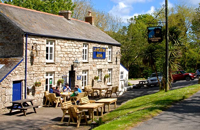 The traditional granite exterior of the Lamorna Wink where tables sit outside so you can enjoy the sun with your pint