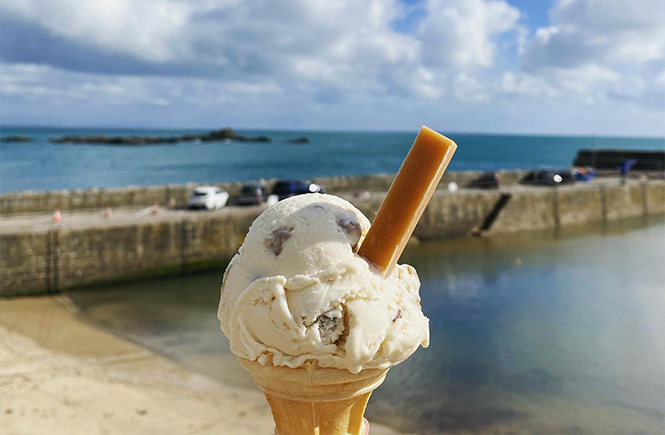 An ice cream by Jessie's Dairy being enjoyed in front of Mousehole harbour