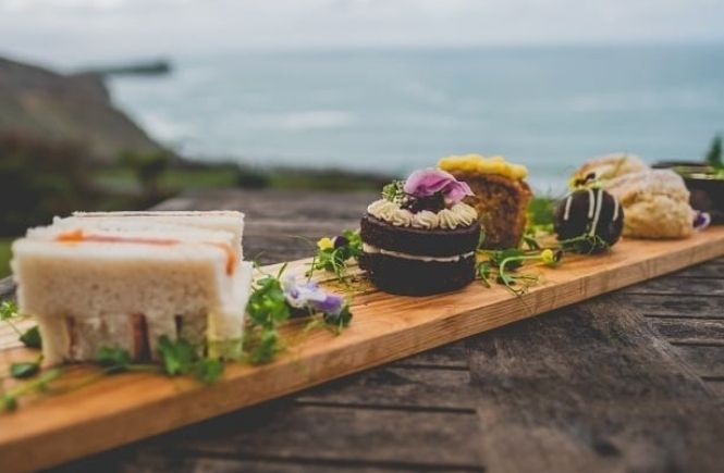 A selection of sandwiches and cakes over looking the cliffs and sea at the Polurrian Hotel