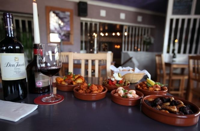 A selection of tapas dishes and a bottle of wine at Estrella Morada
