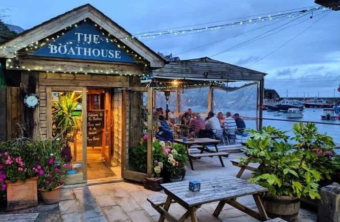 The wooden exterior and outdoor seating at The Boathouse, a dog-friendly restaurant in Newquay
