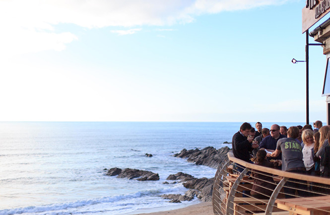 Lots of people standing on the balcony overlooking the sea at The Stable, Fistral