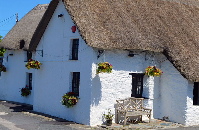 The quaint thatched exterior of Treguth Inn, one of the oldest pubs in Cornwall