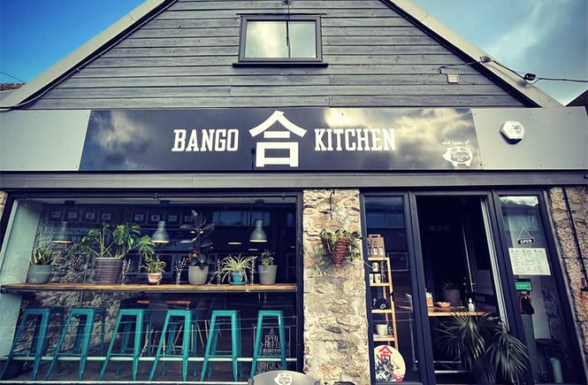 The exterior of Bango Kitchen with seating in the front window