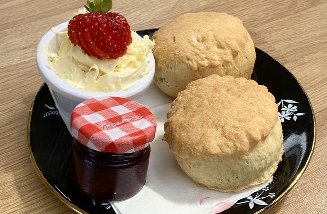 A plate of scones, clotted cream and a tiny jam jar at Apple Tree Café in Penzance