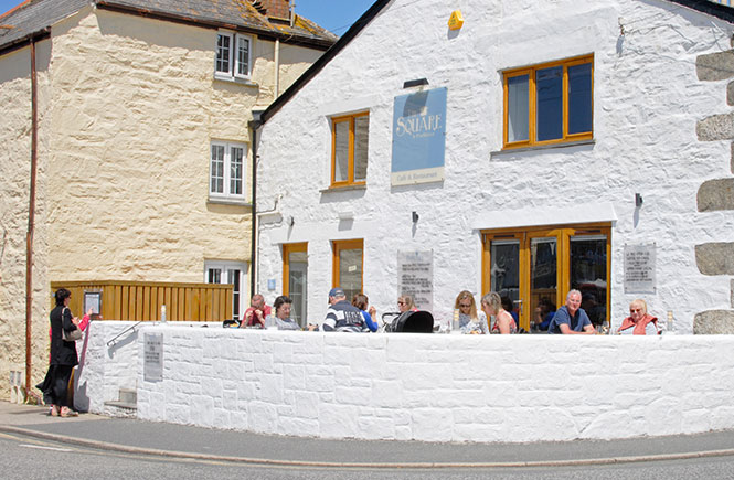 People sitting outside of The Square in Porthleven