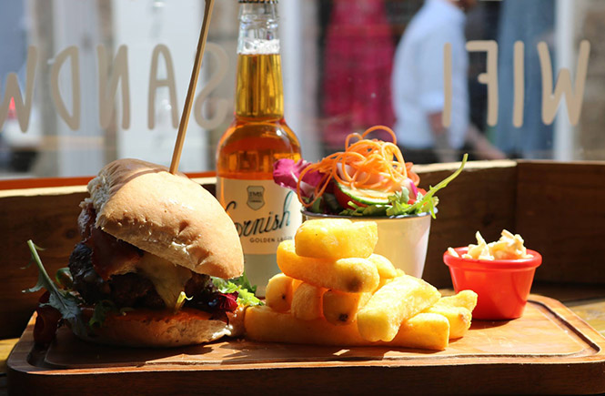 A burger, beer and chips by the window at Scoff Troff Cafe in St Ives