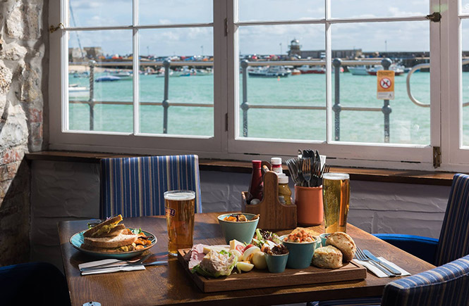 A table full of food overlooking the harbour of St Ives at The Lifeboat Inn