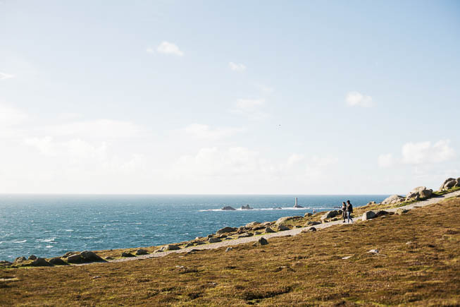 People walking along the South West Coast Path at Land's End with the sea to their right
