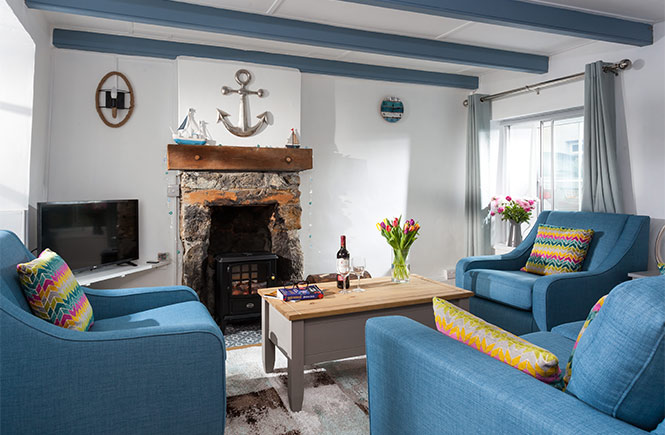 The cosy living room with a fireplace at Mullion Cottage