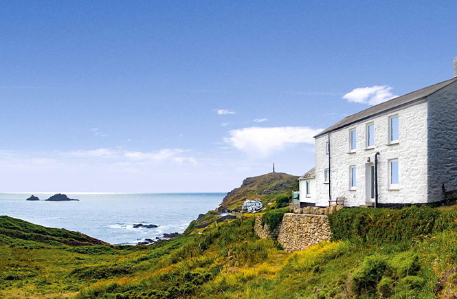 The beautiful white-washed Cove Cottage nestled by the sea at Cape Cornwall