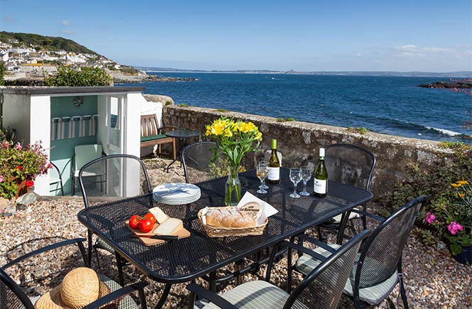 The pretty terrace at St Clements Cottage with sea views over Mousehole harbour