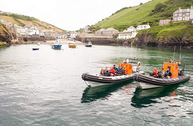 Two Wavehunters boats full of visitors in the harbour of Port Isaac