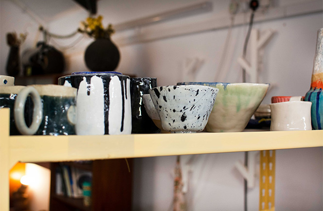 A collection of thrown mugs on a shelf at Wedge Studio in Newquay
