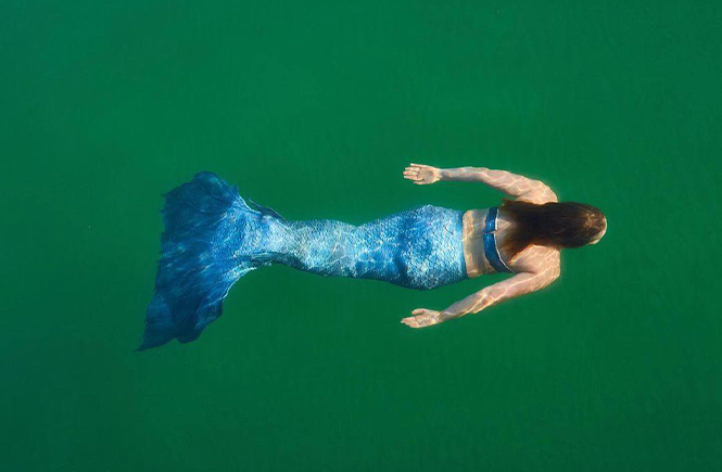 The St Ives Mermaid swimming through azure waters