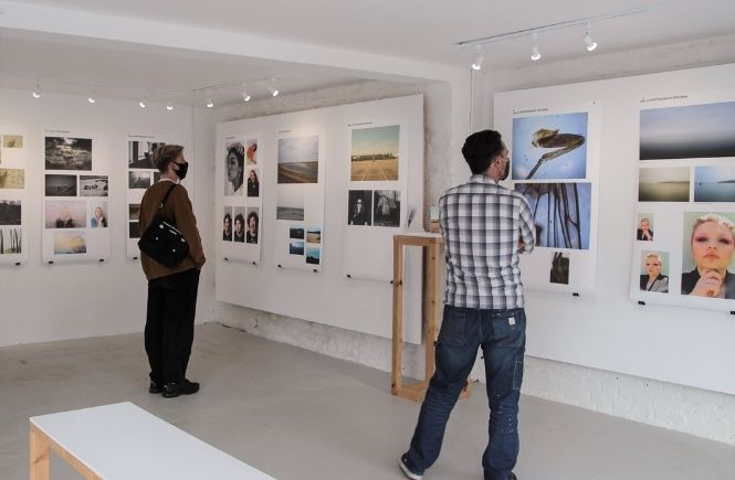 People walking around a photography exhibition by Truro and Penwith students
