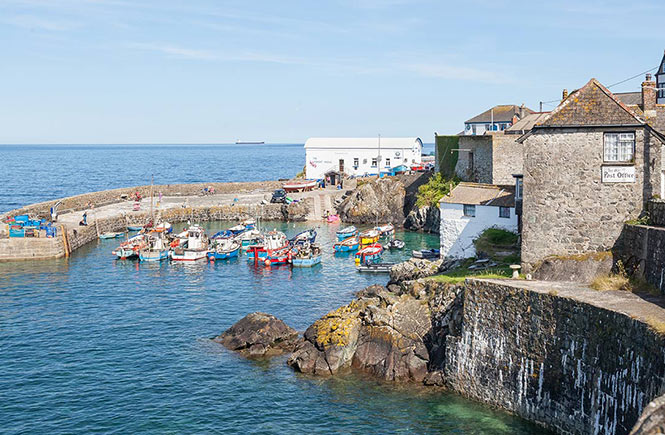 The pretty harbour at Coverack with boats bobbing in the sea
