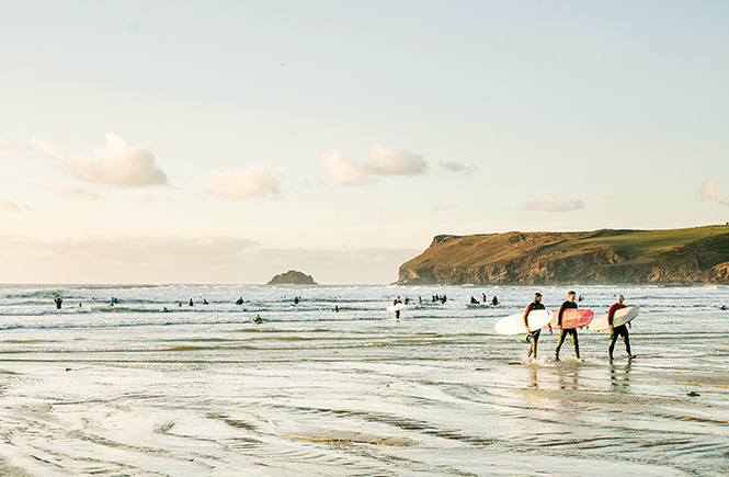 Surfers emerging from the waters at Polzeath in North Cornwall