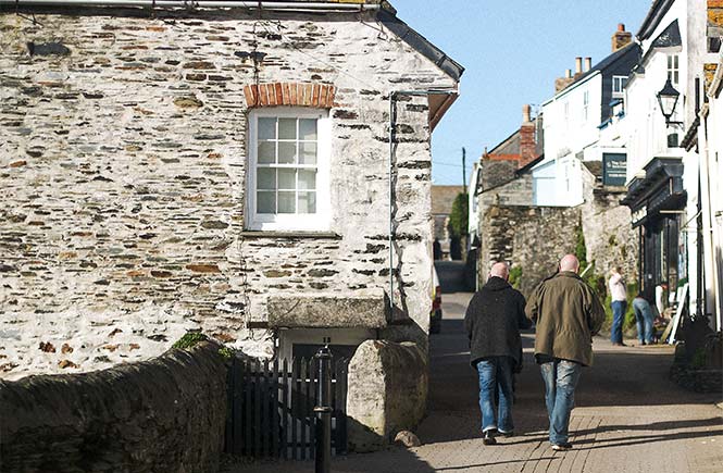 People walking up one of the pretty streets of Port Isaac