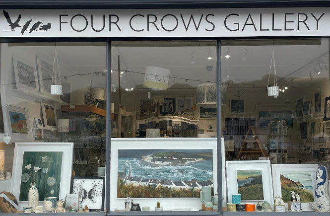 The shop window of Four Crows Gallery in Porthleven, which is full of local arts and crafts