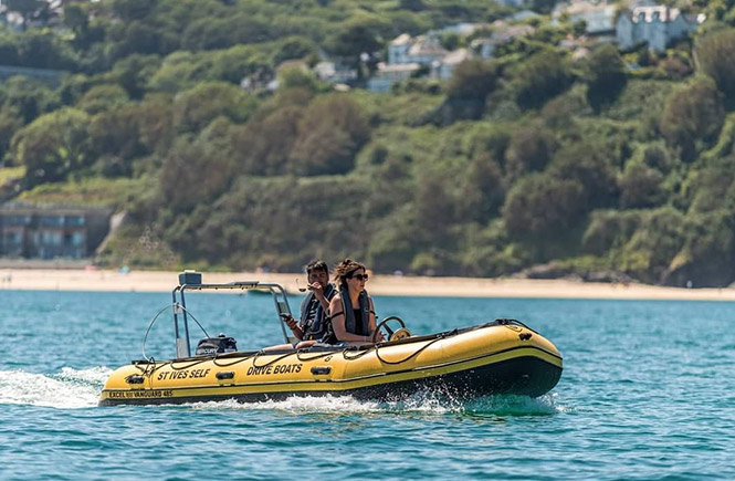 A couple enjoying one of the many self drive motor boats from St Ives Boat Rides in St Ives