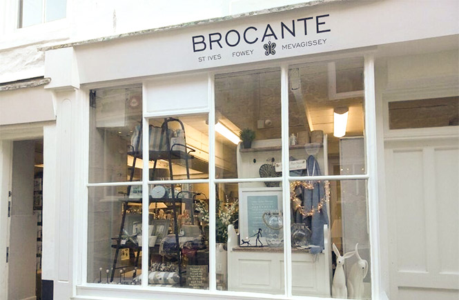 The pretty white exterior of Brocante with a shop window full of stunning interior design