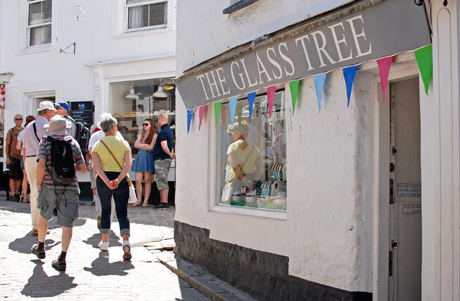 People standing outside The Glass Tree shop down the cobbled street in St Ives