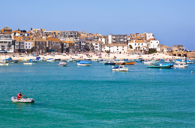 The stunning harbour beach at St Ives, with boats bobbing in the water, one of the best days out in Cornwall
