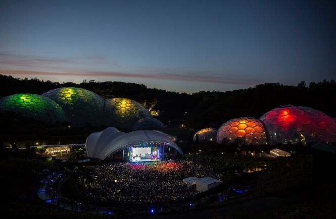 A stage at dusk at the Eden Project with the biomes lit up