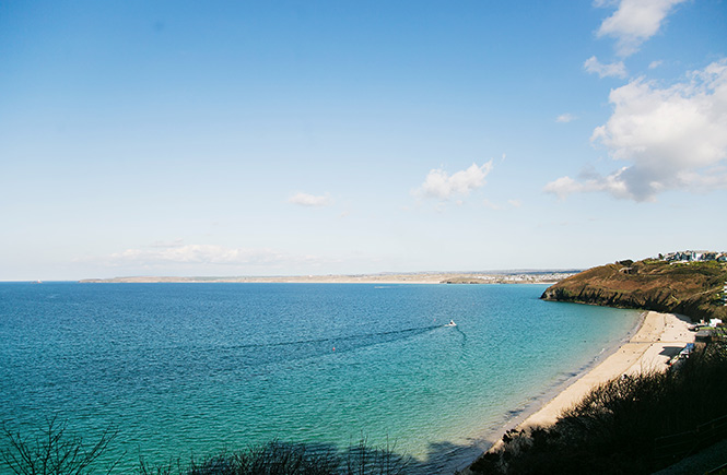 A boat nipping across the azure waters of Carbis Bay in St Ives