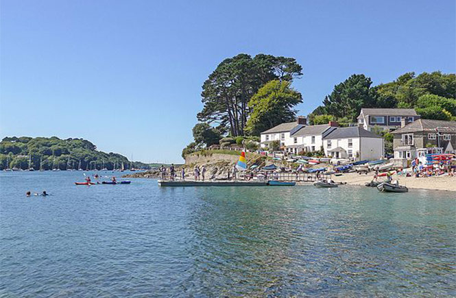 Clear blue waters, white sand and a busy pontoon at Helford Passage beach near Falmouth