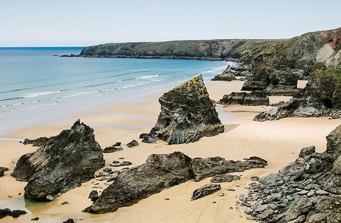 The iconic beach at Bedruthan Steps with huge rock stacks jutting out of the sand