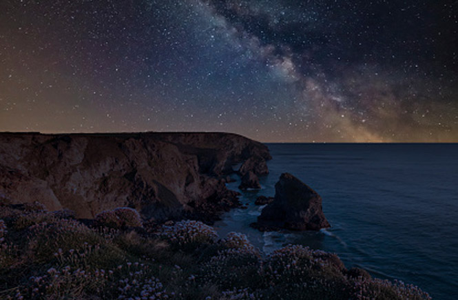 Bedruthan Steps at night with the Milky Way above the cliffs and sea stacks