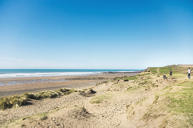 People walking on the sand dunes above Widemouth Bay in Bude