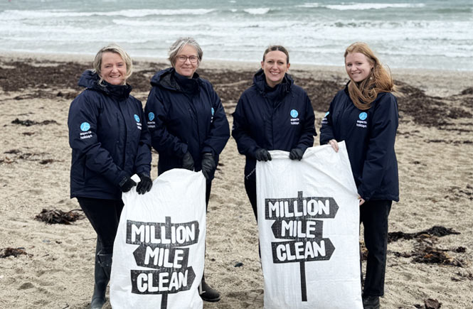 Gemma, Claudine, Gemma and Mia hold bags of rubbish they have collected