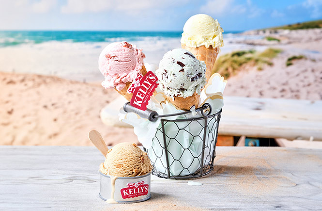 A basket full of ice cream cones and ice creams from Kelly's with the beach in the background
