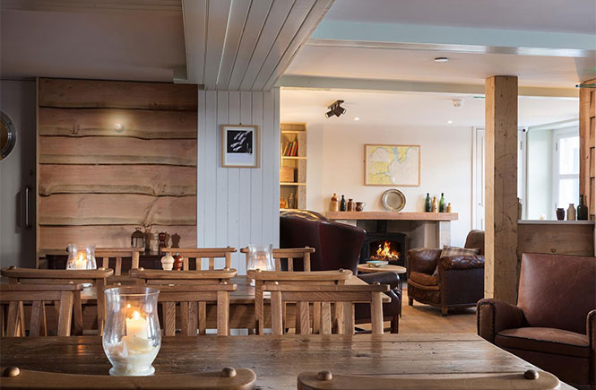 The cosy dining room at Pennycomequick with a fireplace in the background