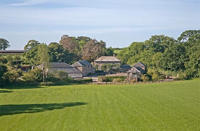 Looking across a field at the traditional Coombeshead Farm