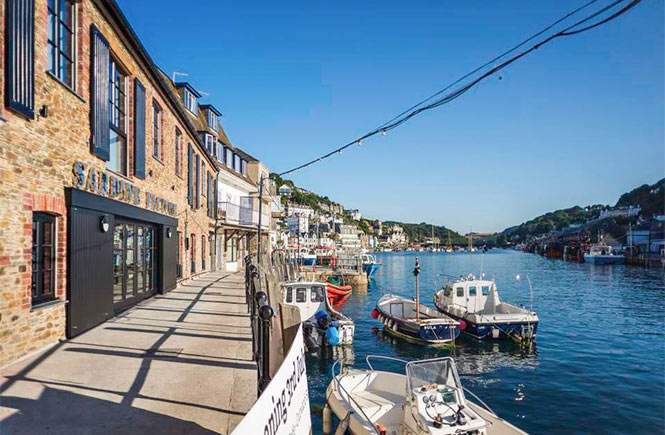 The Sardine Factory perched on the harbour's edge in Looe, Cornwall