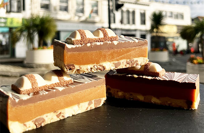 Three millionaires shortbreads on a platter with colourful flags in the background