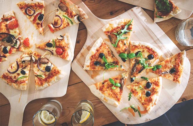 Pizzas cut up on wooden boards at The Angry Anchovy in Port Isaac