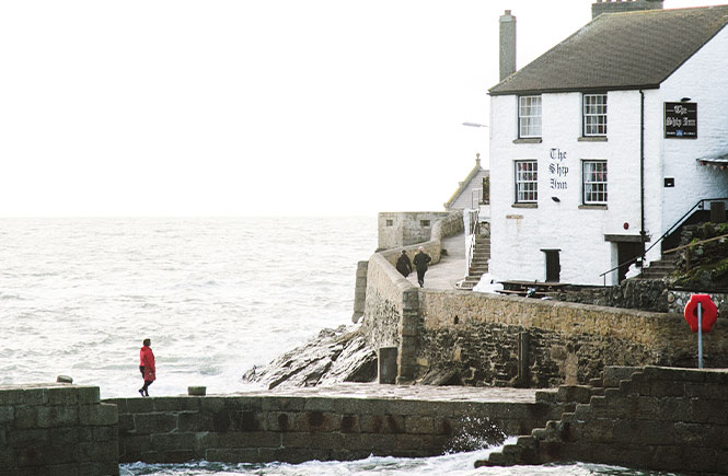 The Ship Inn sitting above Porthleven harbour with the tide in