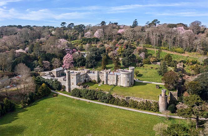 A bird's eye view of the pretty Caerhays Castle surrounded by beautiful gardens